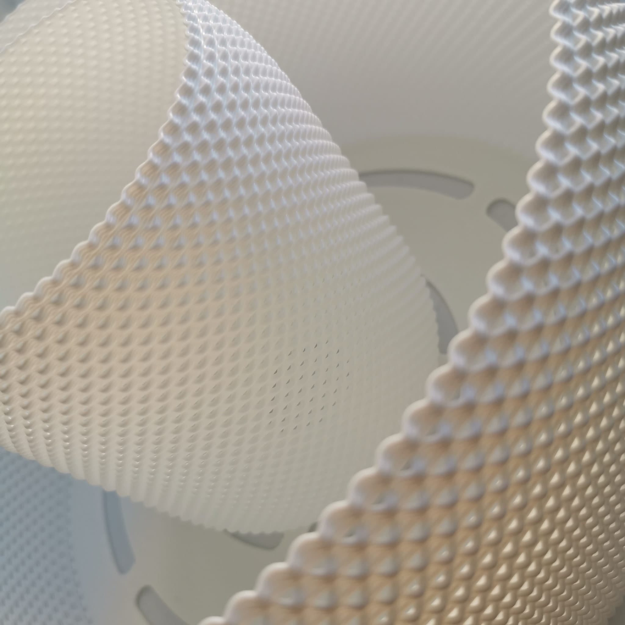 Close-up detail of the woven texture and surface pattern of a designer pendant lamp shade.