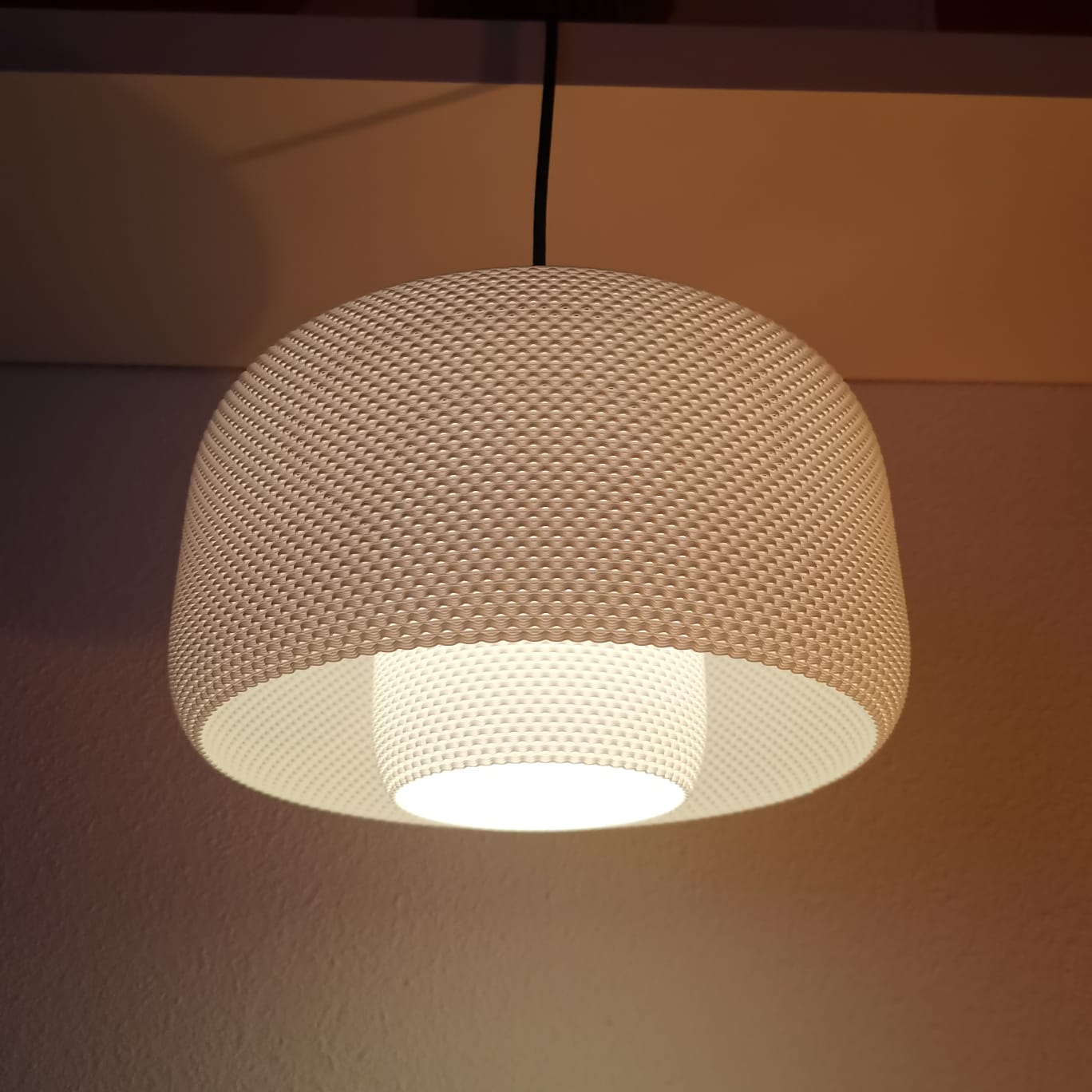 Textured pendant light fixture on a neutral background