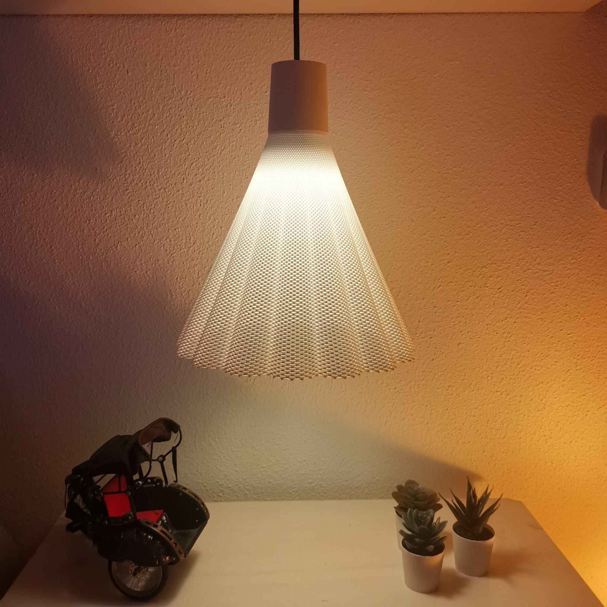 Modern pendant light with a textured shade on a wall-mounted shelf with decorative items.