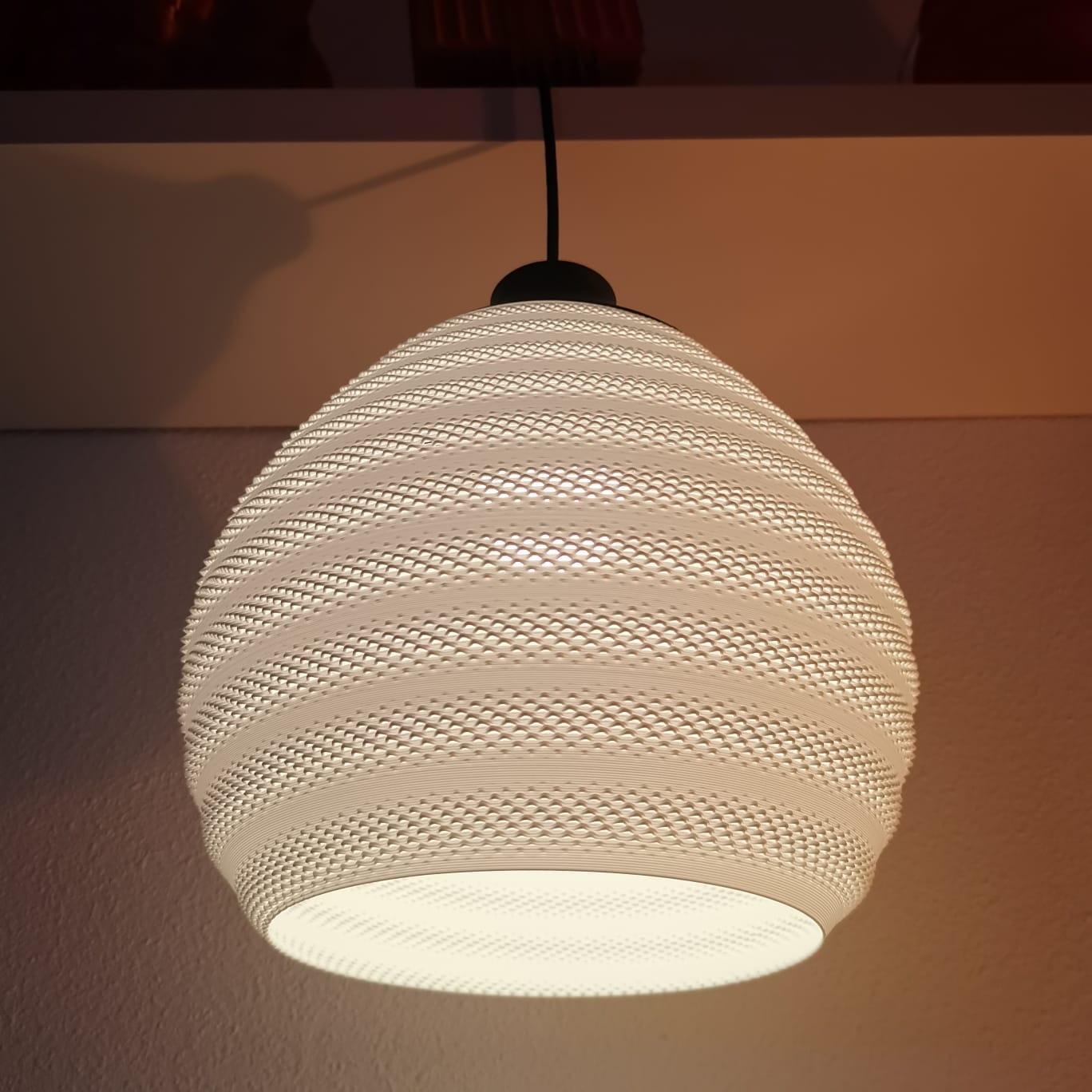 Textured pendant light fixture on a neutral background