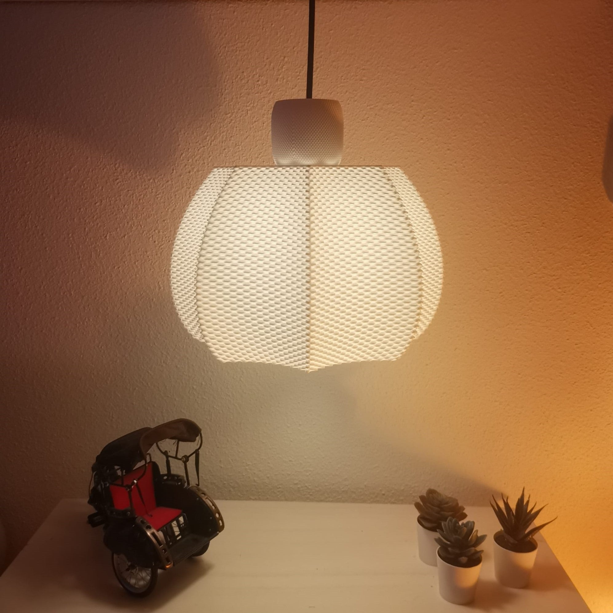 Ceiling light fixture casting a warm glow on a wall with decorative items below.