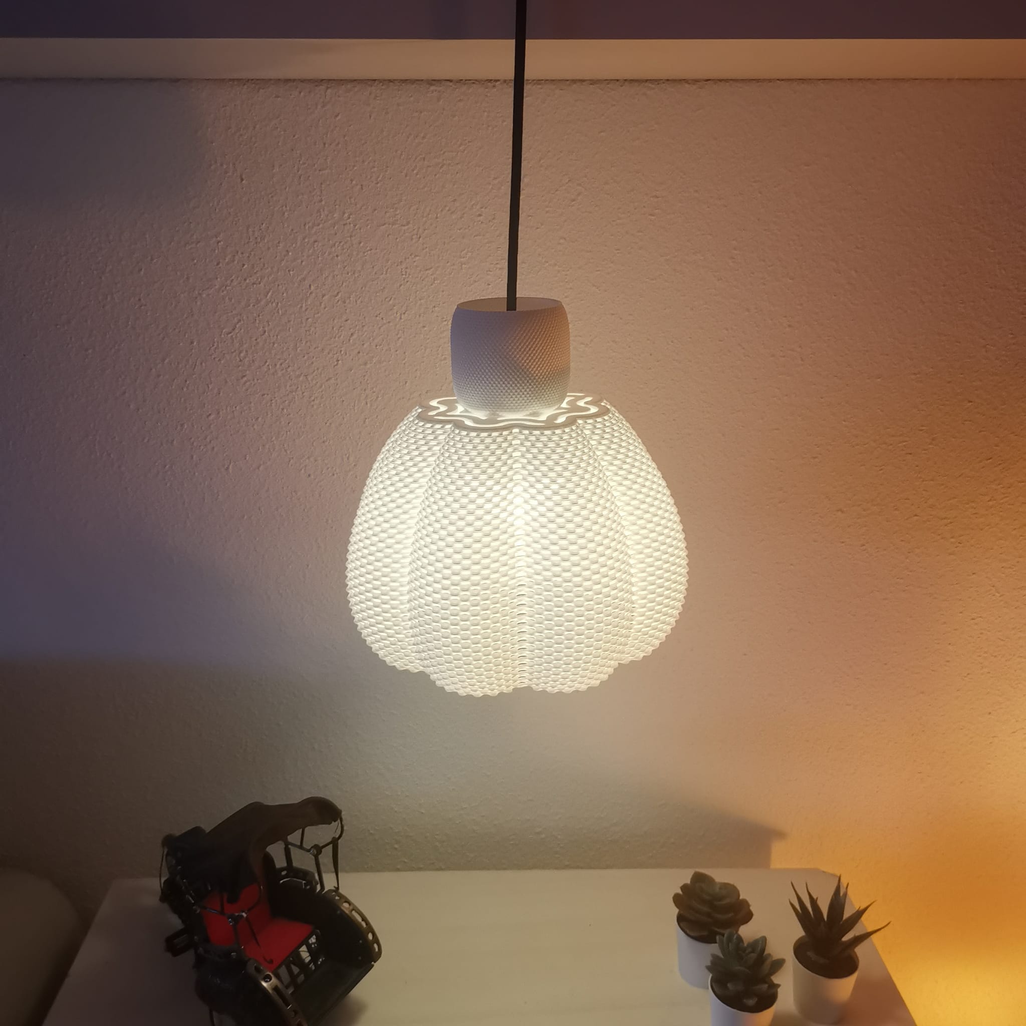 Decorative light bulb on a table with a soft glow against a neutral wall.