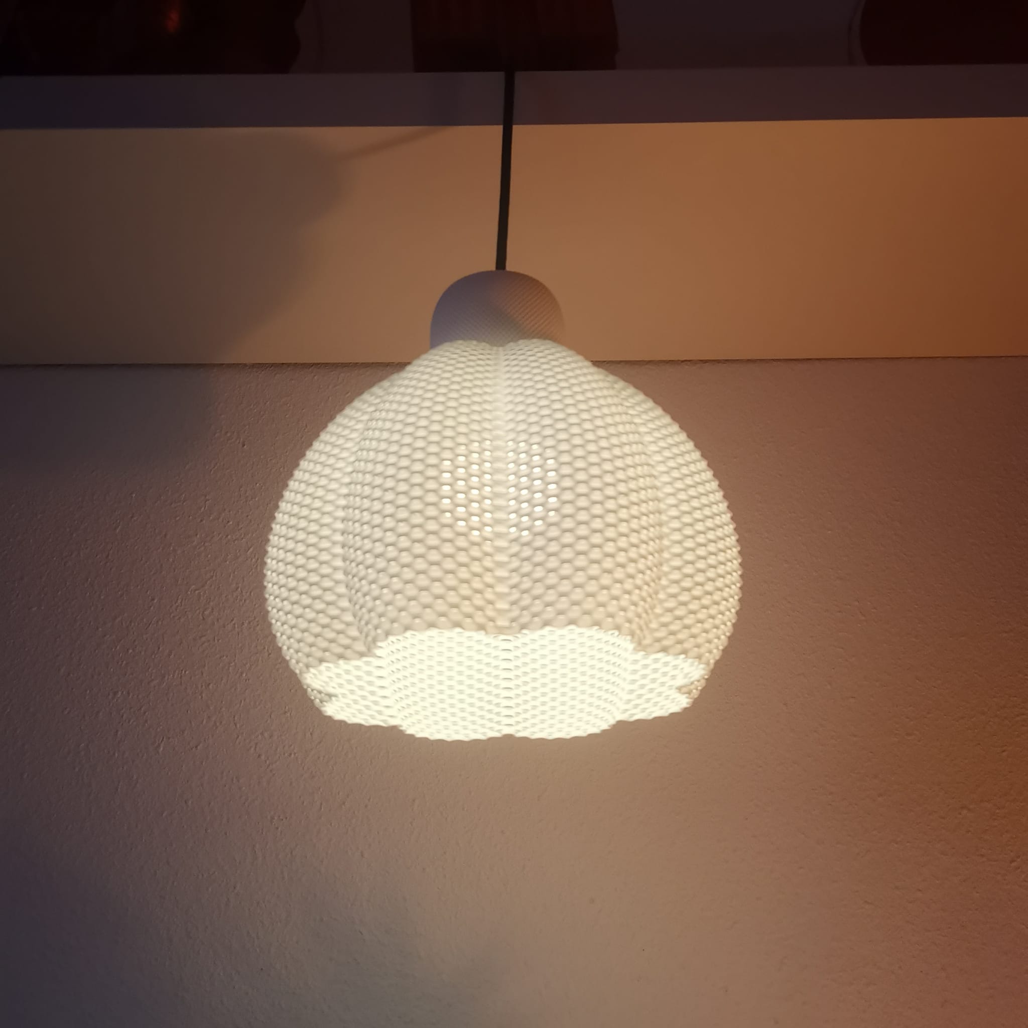 Textured light bulb hanging against a neutral background