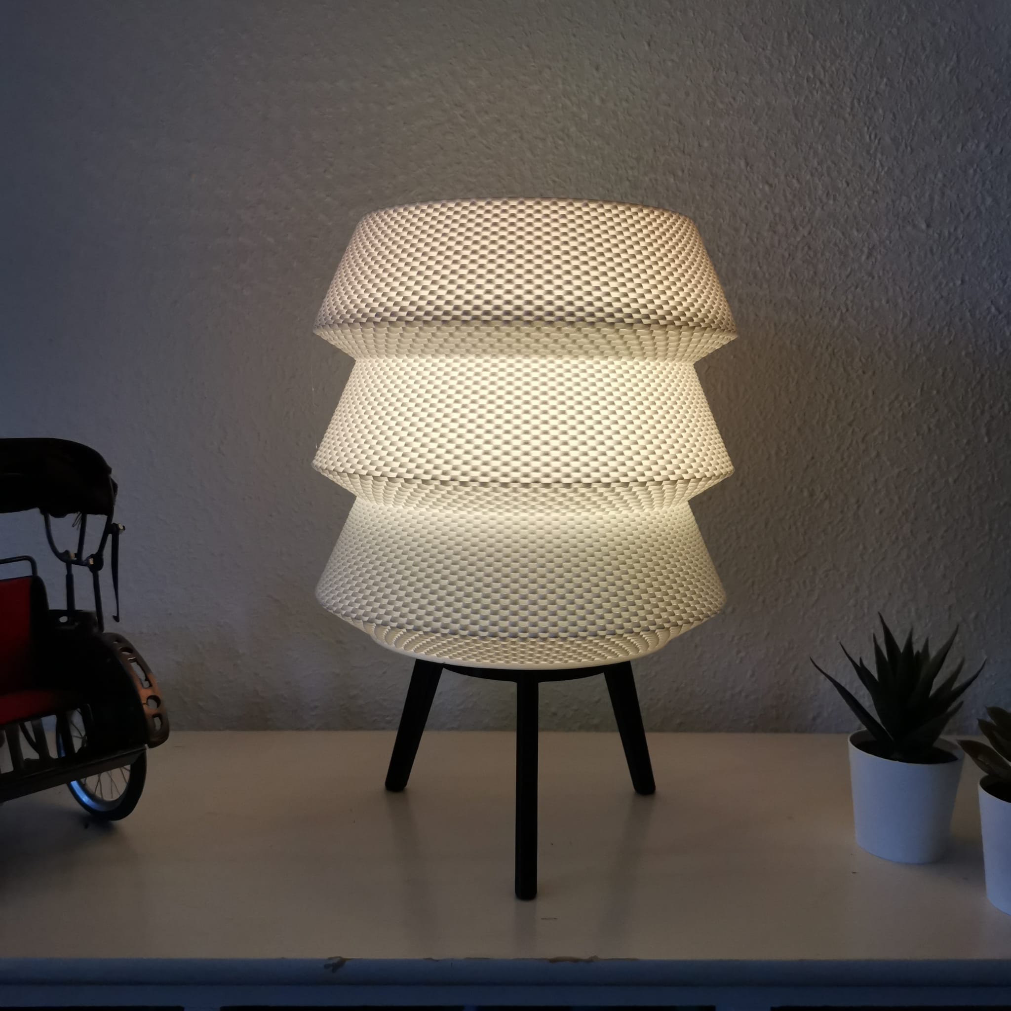 Modern lamp with a textured design on a white surface against a plain wall.