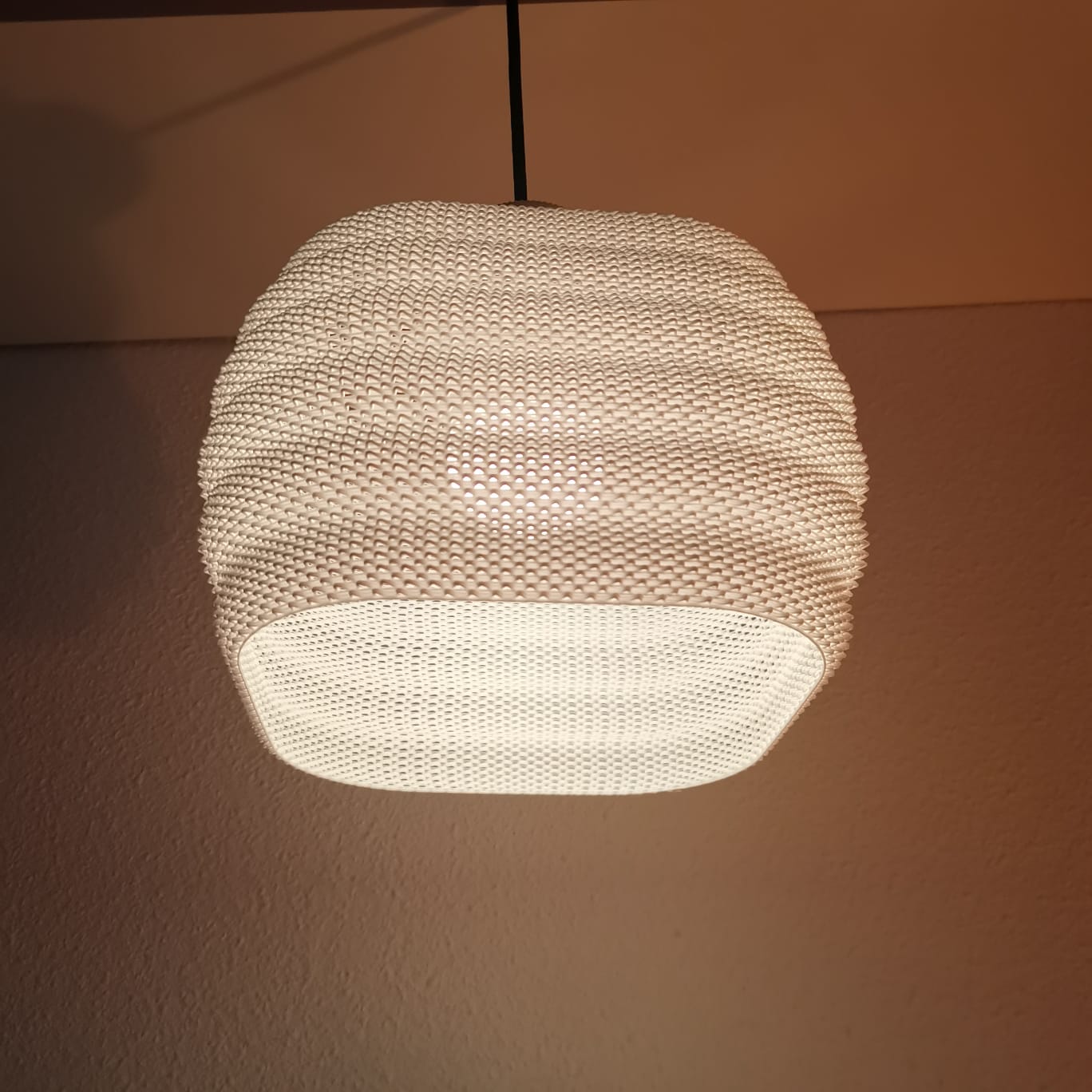 Textured pendant light fixture on a plain wall