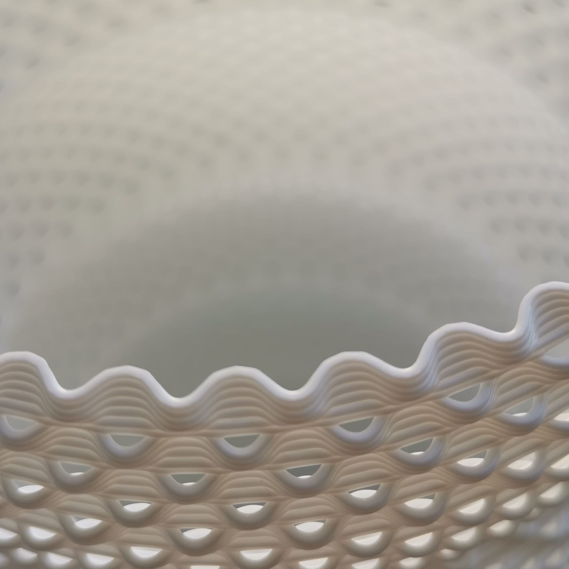 Close-up of a textured table lamp with wavy edge on a light background