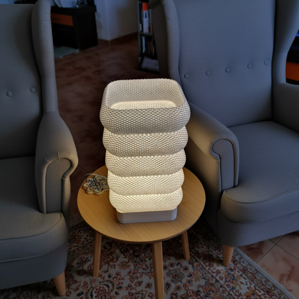 Stacked lamp on a small round table between two chairs in a room.