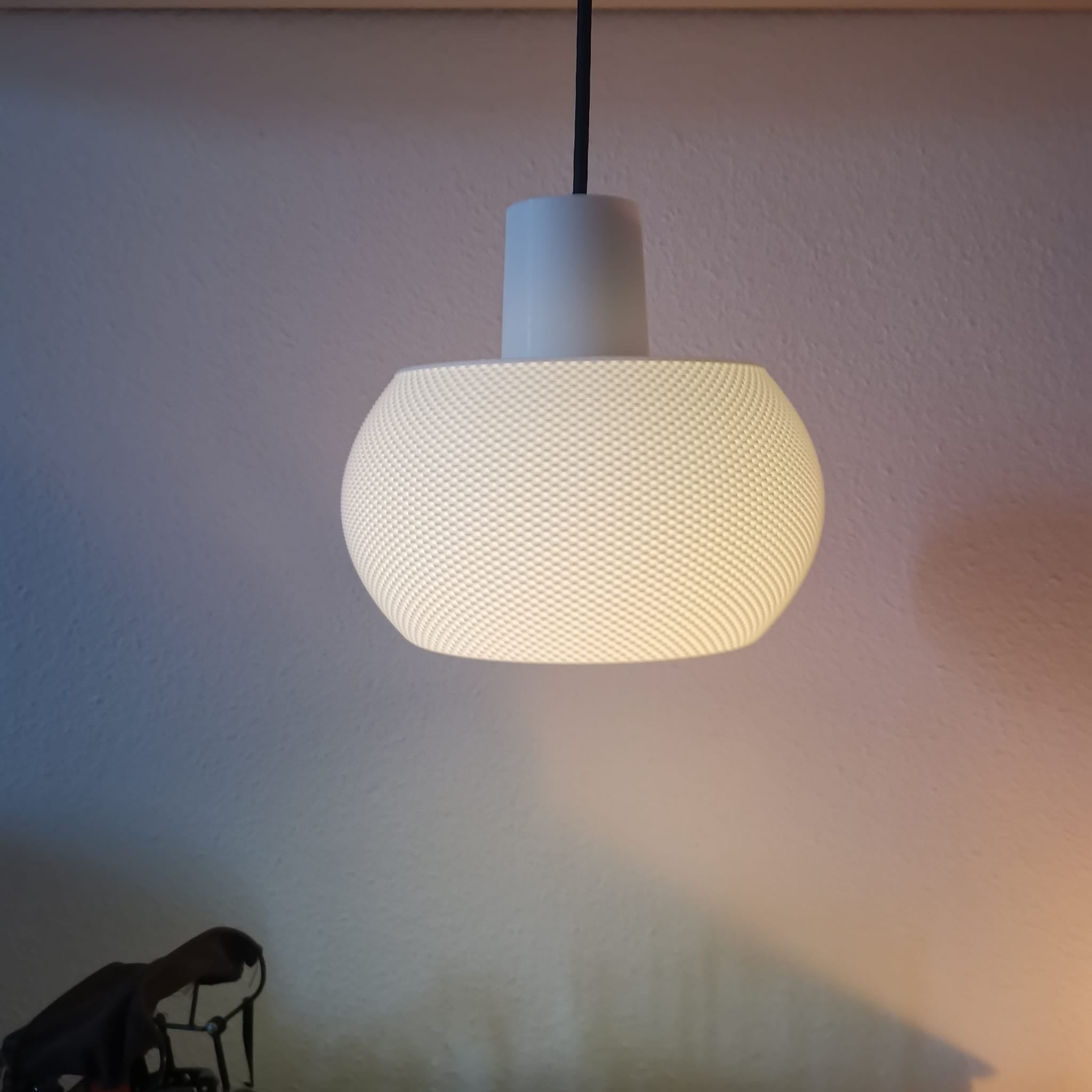 Textured pendant light hanging against a plain wall
