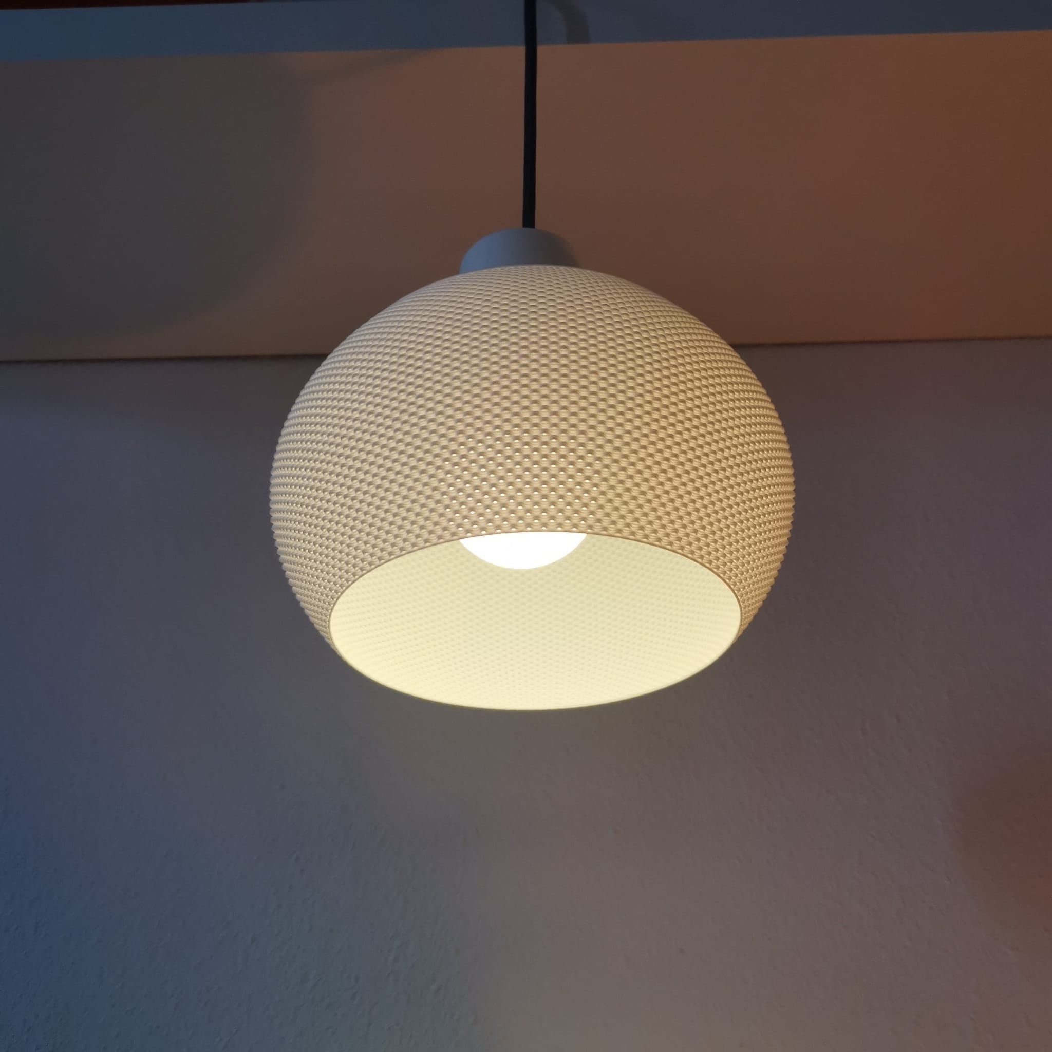 Textured pendant light hanging against a plain wall