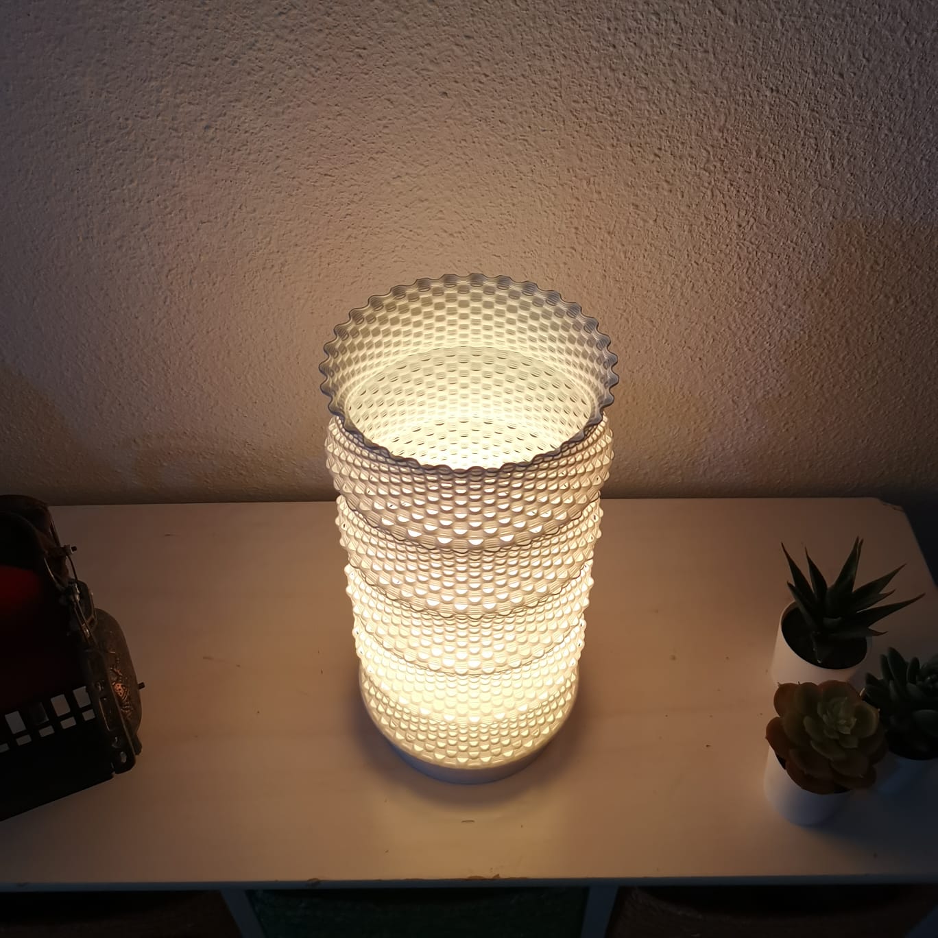 Decorative table lamp with a warm glow on a table.
