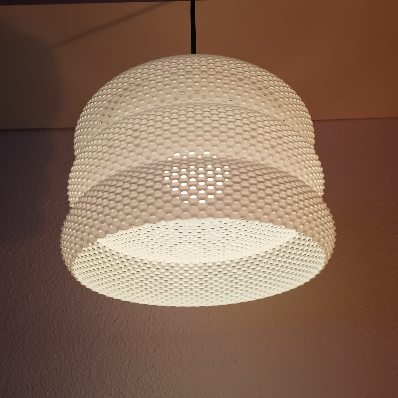 Woven pendant light fixture on a plain background