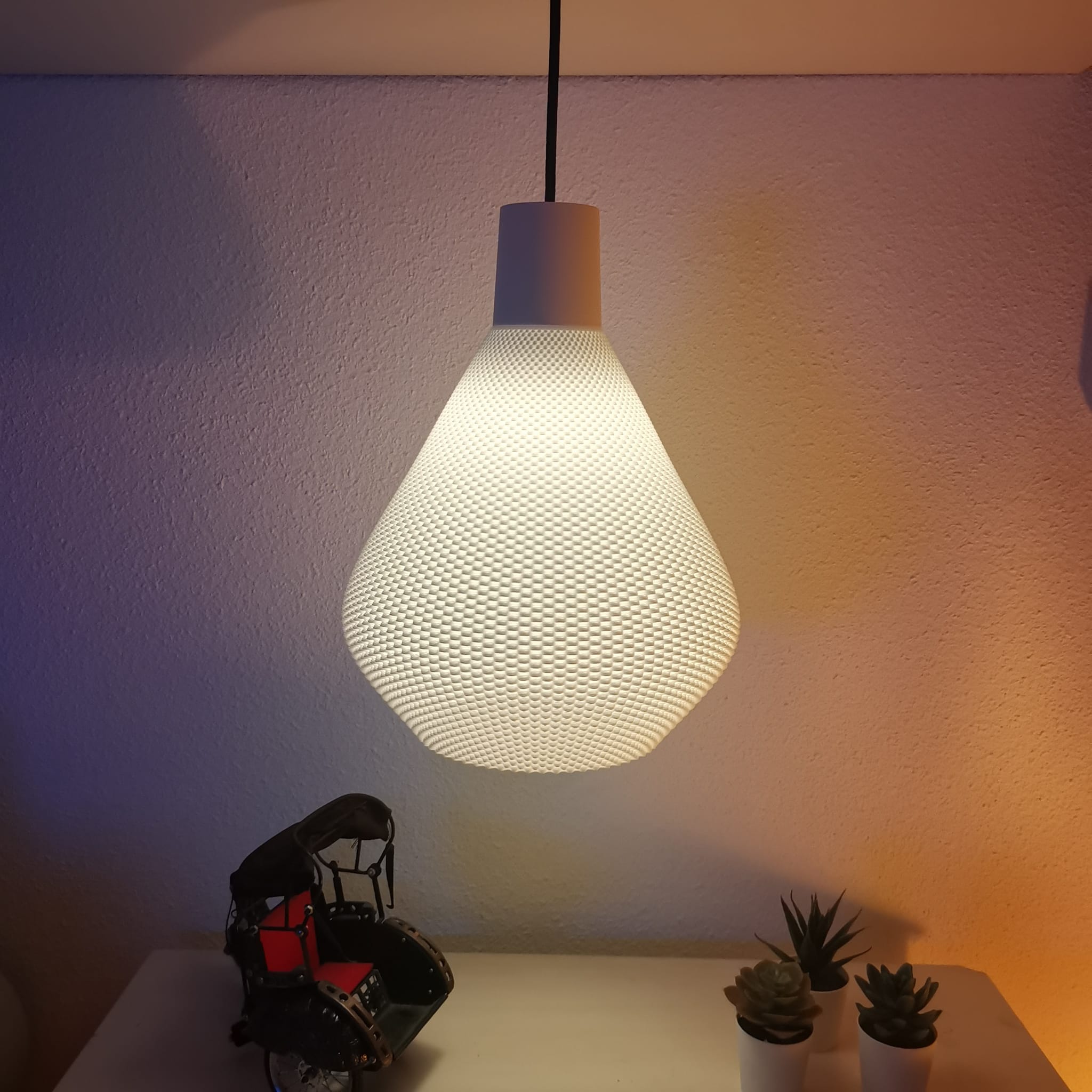 Textured pendant light fixture on a white surface with a soft purple wall background