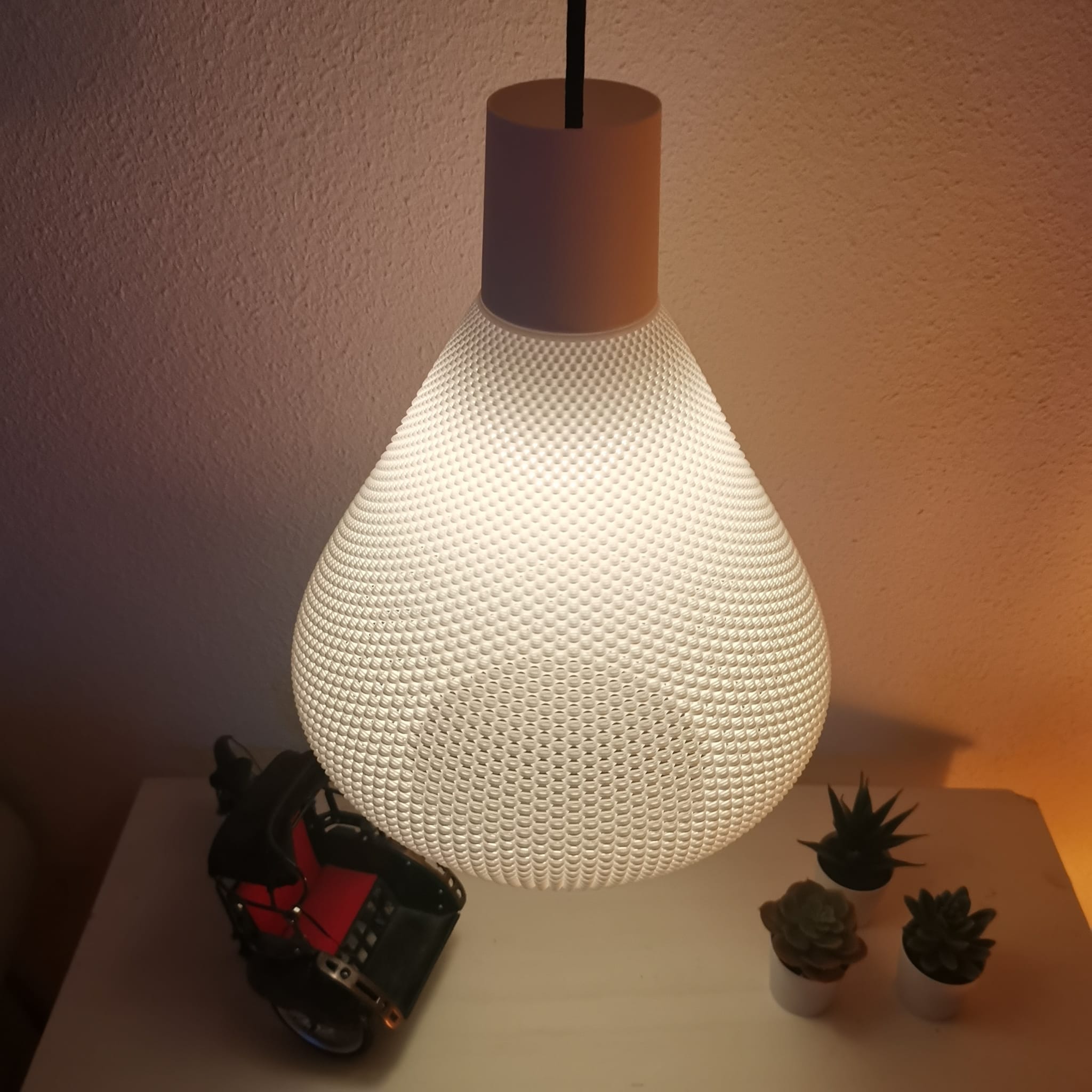 Textured lamp on a surface with small plants