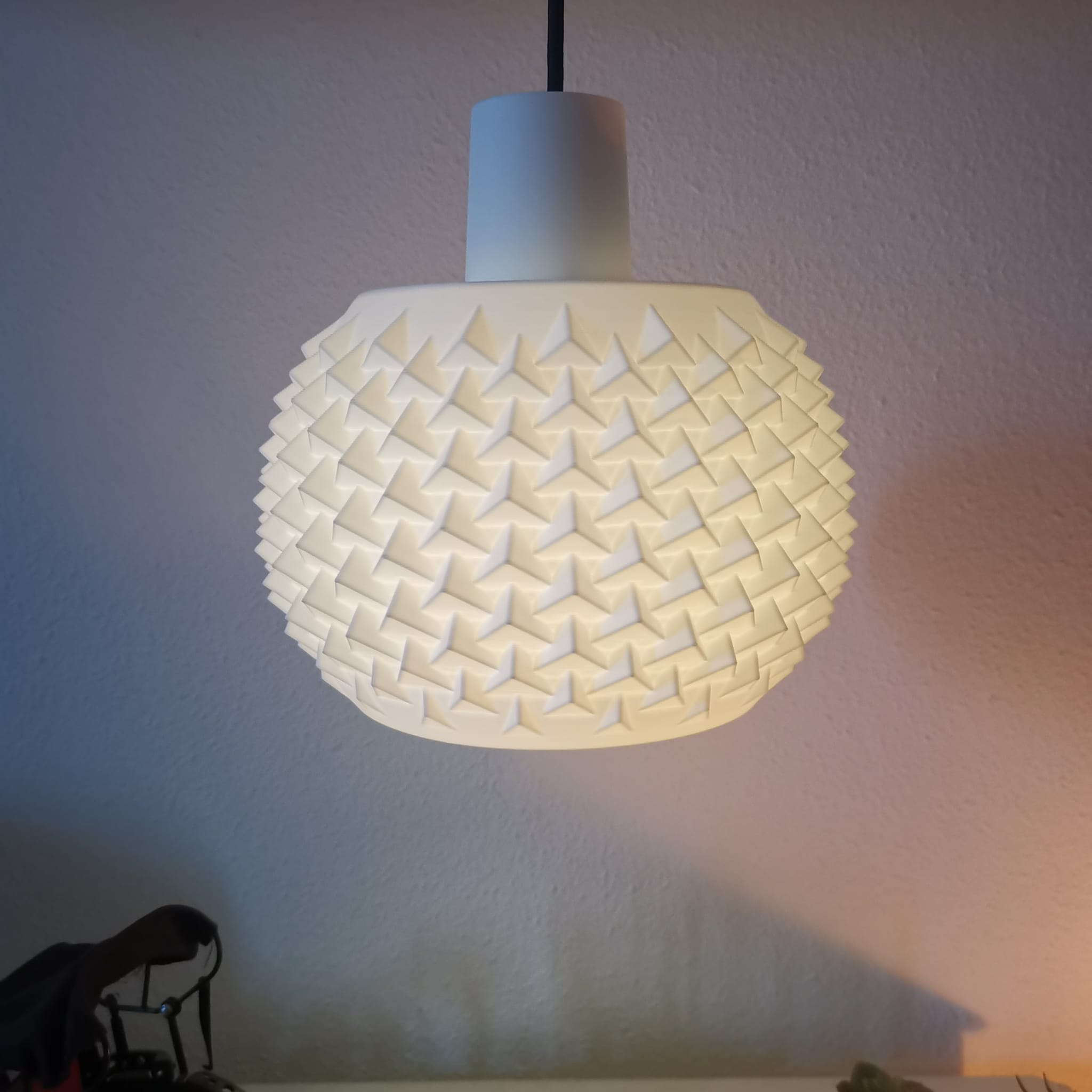 Decorative lamp with woven design on a plain wall