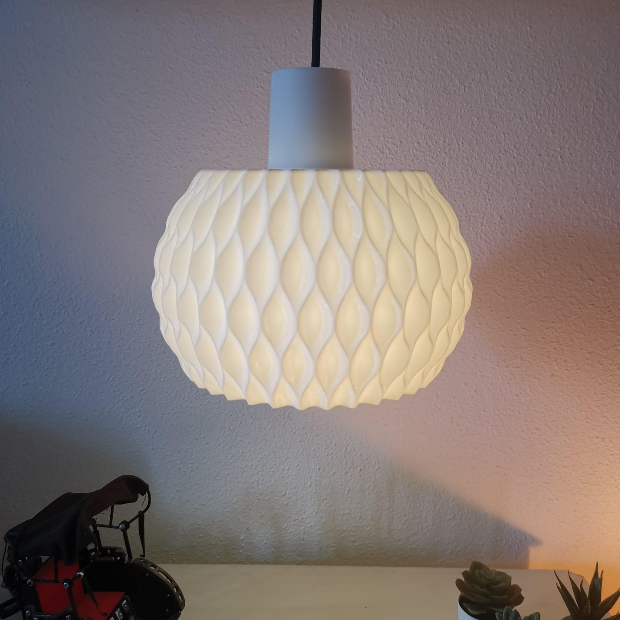 Decorative pendant light with textured design on a neutral background
