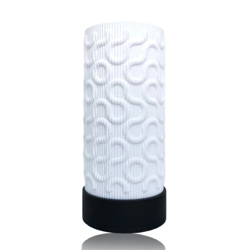 White textured cylindrical table lamp with black base on a white background