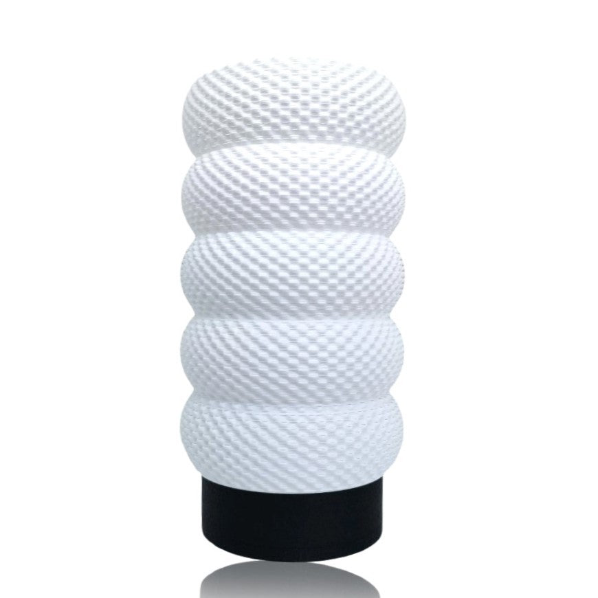 White textured lamp with black base on a white background
