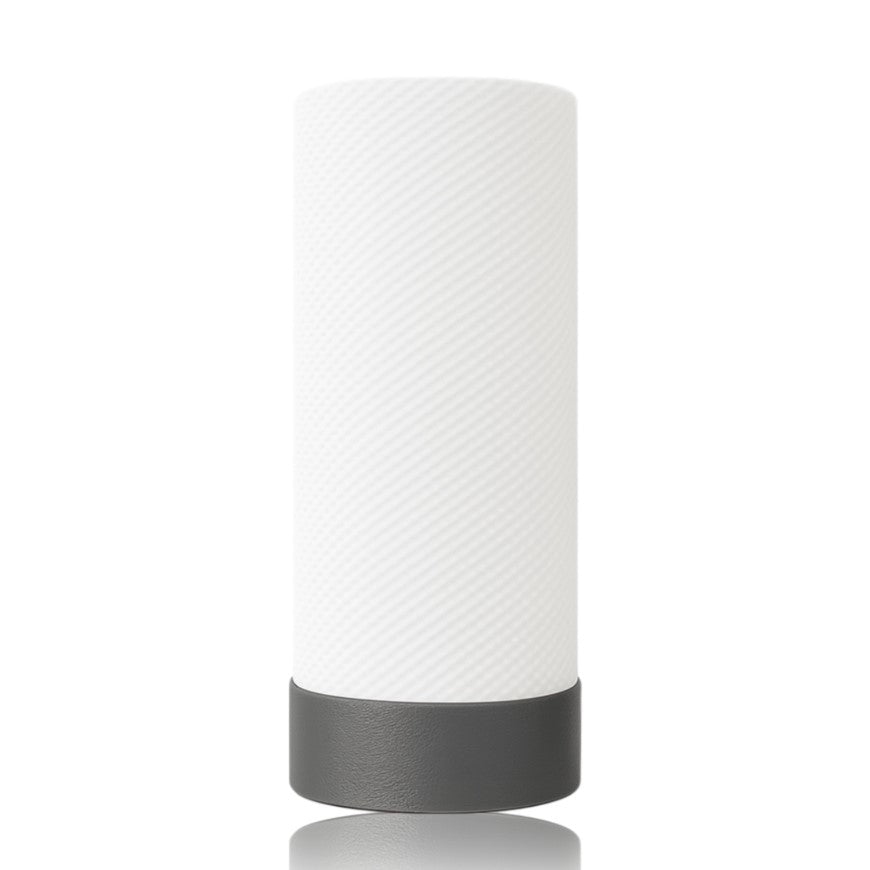 White cylindrical table lamp with a textured surface and black base on a white background