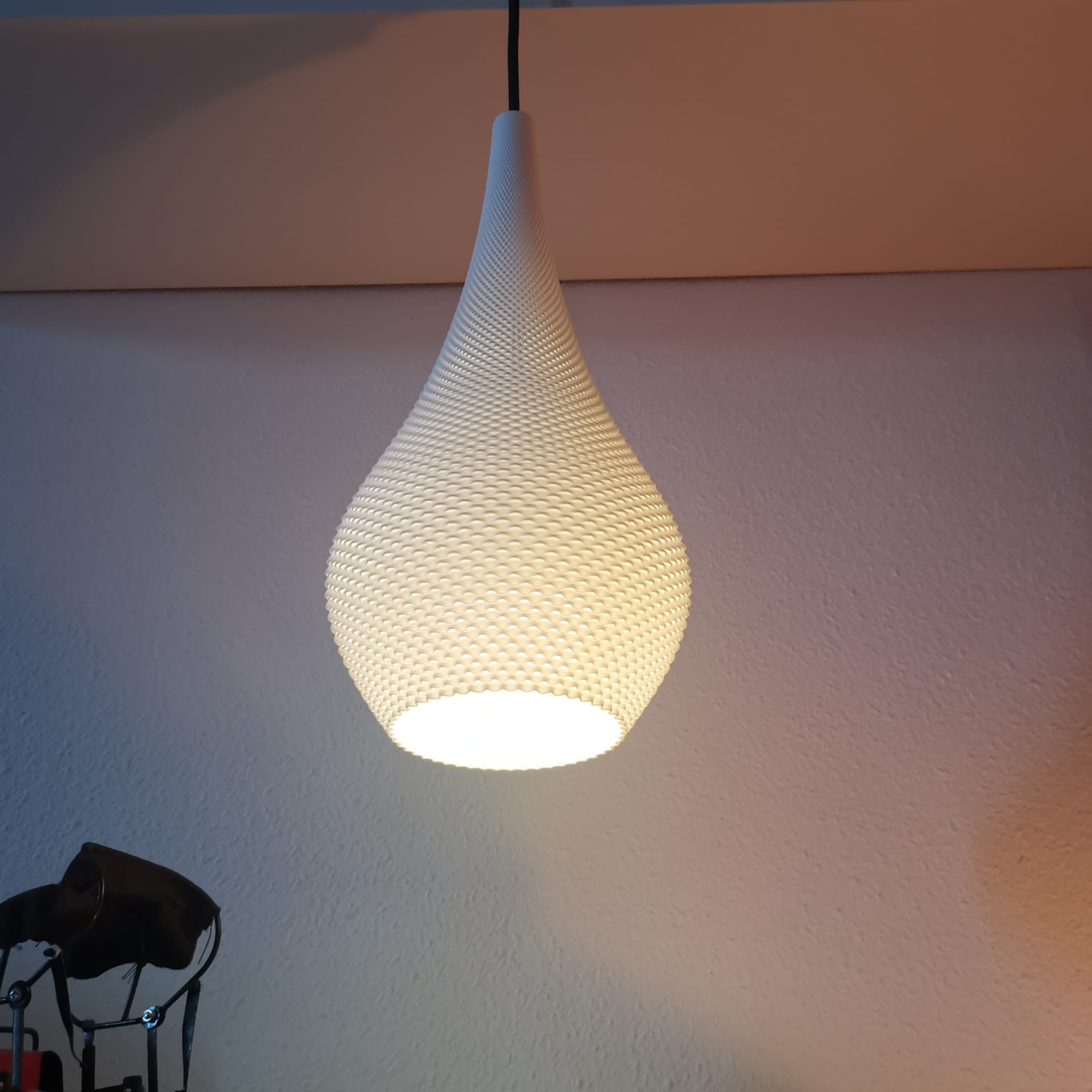 Textured pendant light hanging against a plain wall