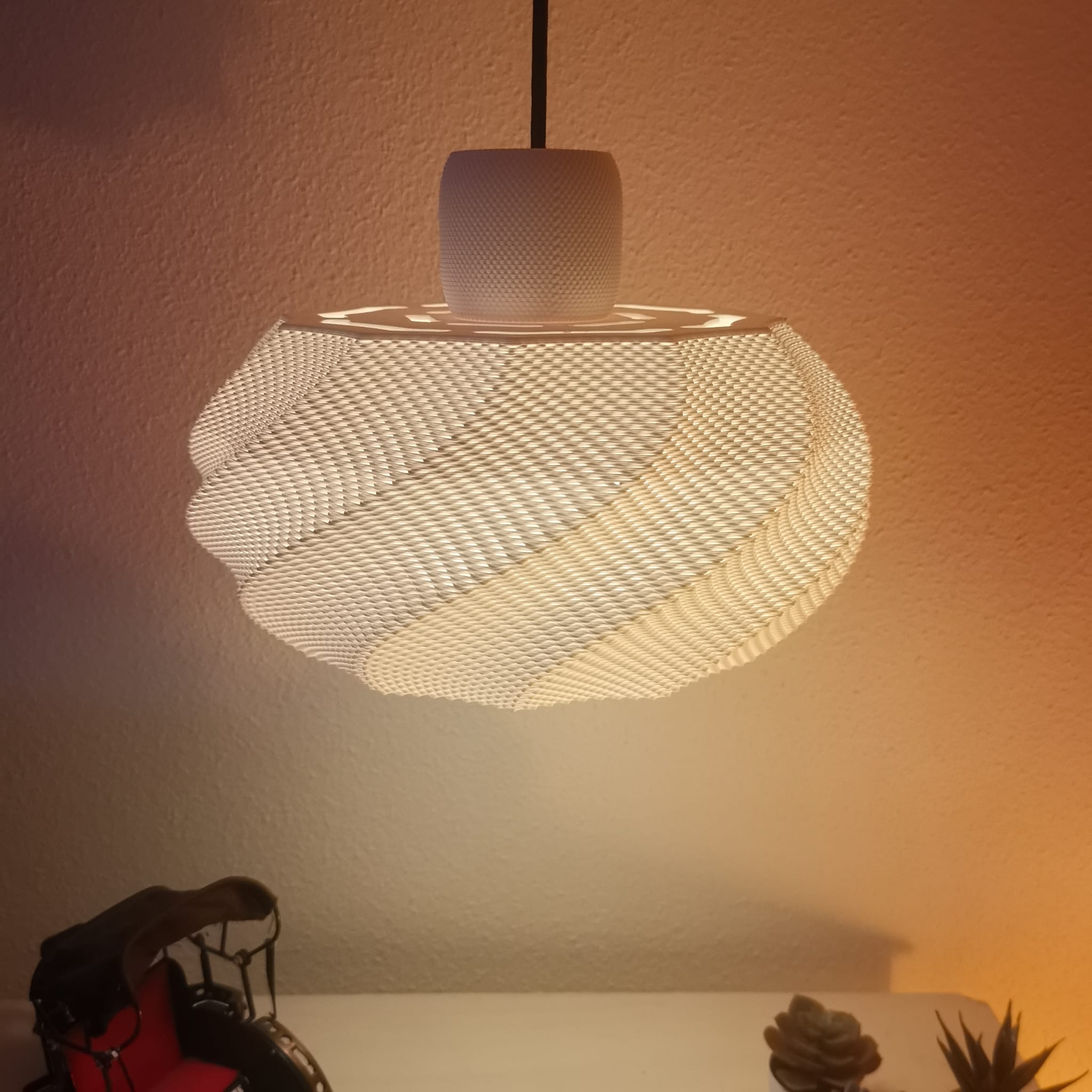 Modern pendant light with a textured design on a warm-toned wall.