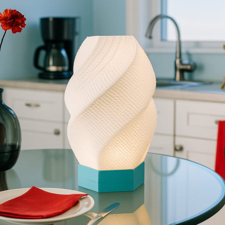 Decorative lamp on a kitchen table with a coffee maker and sink in the background.