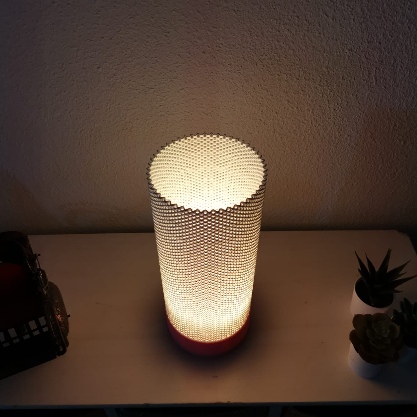 Textured cylindrical lamp on a surface with a minimal background