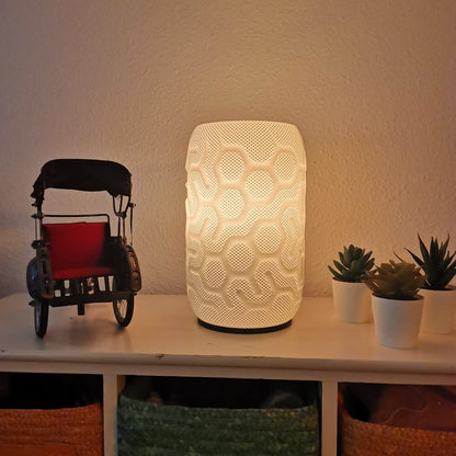 Decorative lamp with geometric pattern on a shelf with a toy and plants