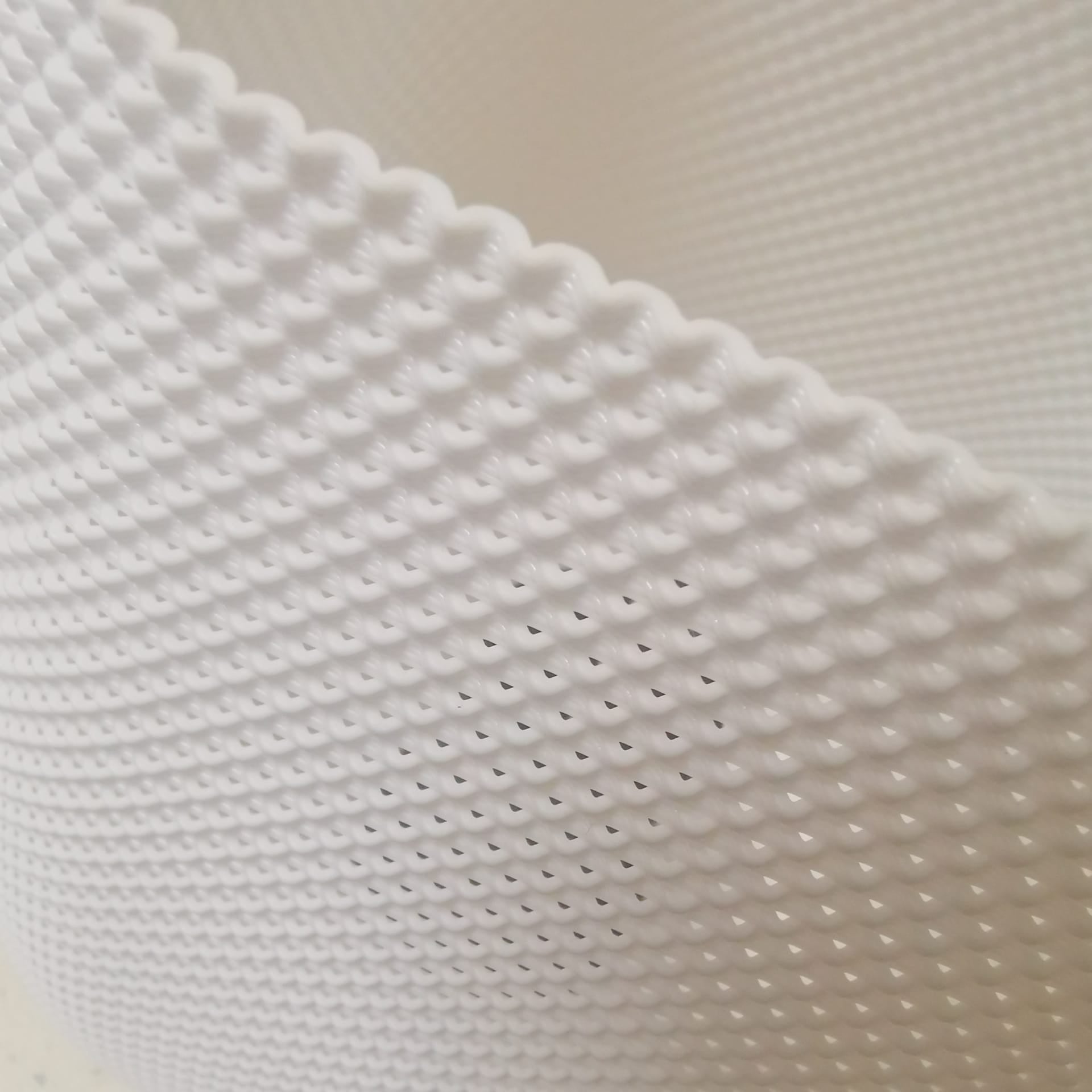 Close-up of textured white lamp surface showing intricate 3D pattern, modern handcrafted lighting design detail.