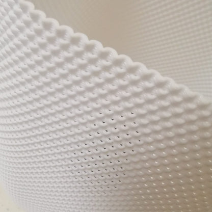Close-up of textured white lamp surface showing intricate 3D pattern, modern handcrafted lighting design detail.