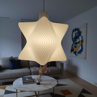 Close-up of a sculptural white pendant lamp illuminating a contemporary living room with sofa and abstract wall art.