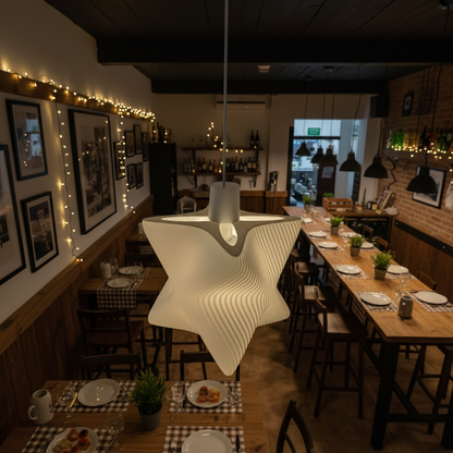 Artistic white pendant lamp suspended above rustic wooden tables in a cozy restaurant interior with warm lighting.