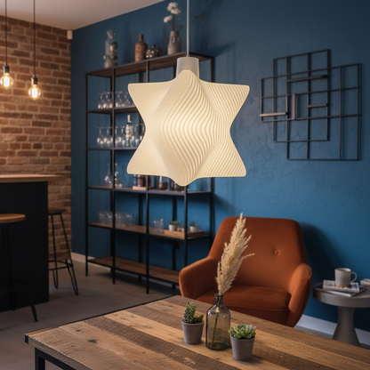 Modern sculptural pendant lamp hanging above a wooden table in a contemporary lounge with blue accent wall.