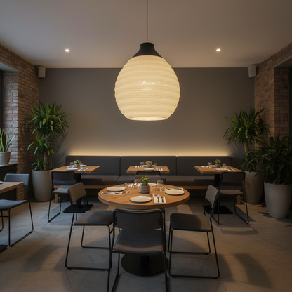Atmospheric pendant lamp with an organic shape and warm light in a modern restaurant interior.