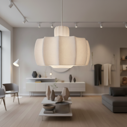 Large white design pendant lamp in a modern interior with wooden flooring, minimalist furniture, and geometric ceramic decor pieces.
