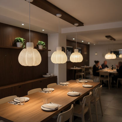 Dining area with wooden tables, chairs, and pendant lights in a restaurant setting.