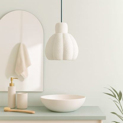 Bathroom setup with a mirror, lamp, sink, and toiletries on a light green countertop.