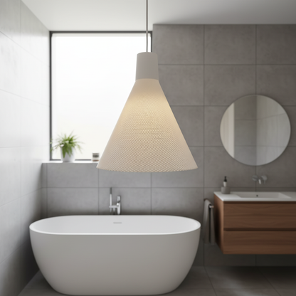 Minimalist white cone-shaped pendant light hanging above a freestanding bathtub in a modern gray tiled bathroom.