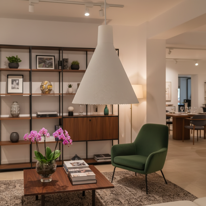 White textured cone pendant light hanging above a living room seating area with shelving and warm ambient lighting.