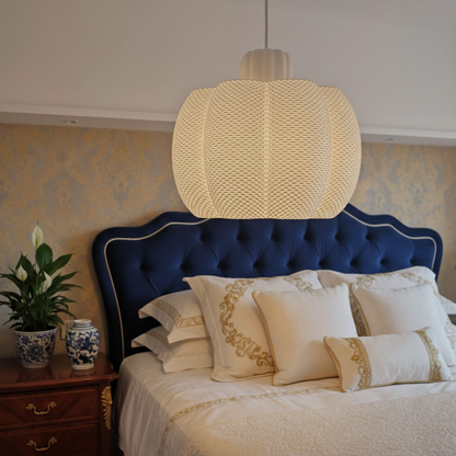 Textured white pendant lamp hanging above a luxury bedroom bed with soft ambient lighting.