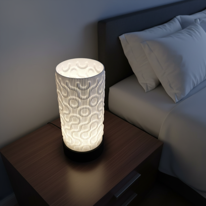 Decorative table lamp with a textured design on a nightstand next to a bed.