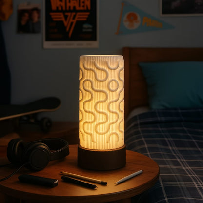 Decorative lamp on a bedside table with skateboard, headphones, and phone in a bedroom setting