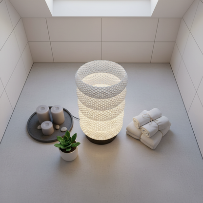 Decorative lamp with candles and towels on a light gray floor.