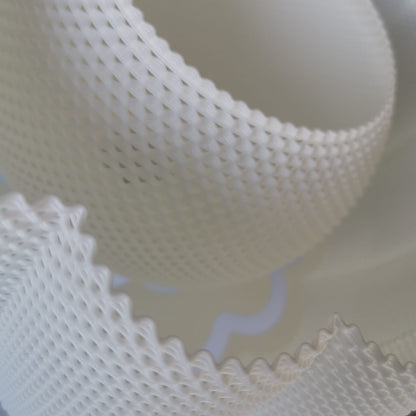 A close-up view of the lamp’s intricate 3D-printed texture, showing the detailed mesh-like pattern and curved scalloped edges.
