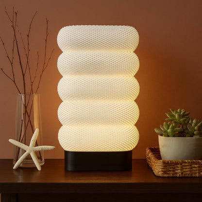 Textured table lamp on a wooden surface with decorative items