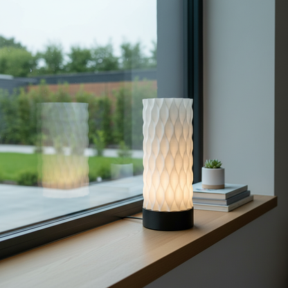 Decorative table lamp on a windowsill with a view of greenery outside