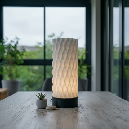Decorative table lamp with textured design on a wooden surface, blurred greenery in the background