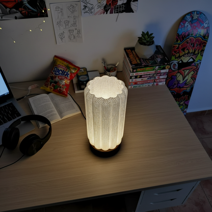 Lamp on a desk with books, snacks, and a skateboard in the background