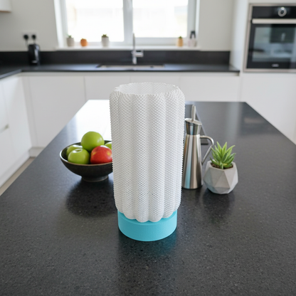 Kitchen counter with a dish drying rack, bowl of apples, and geometric plant pot.