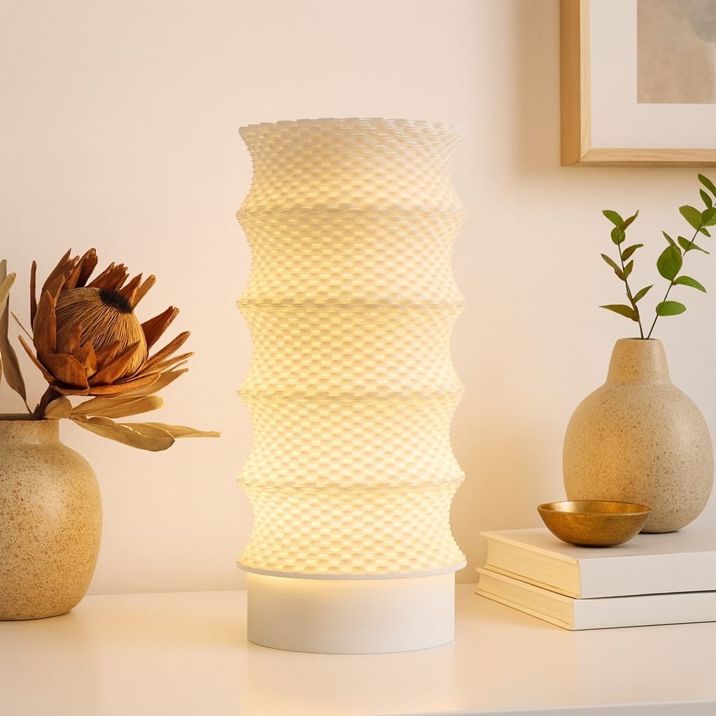 Decorative lamp with textured design on a table with books and vases.