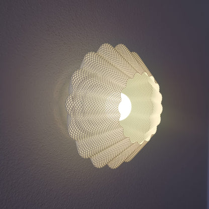 Modern wall light fixture with a textured design on a dark background